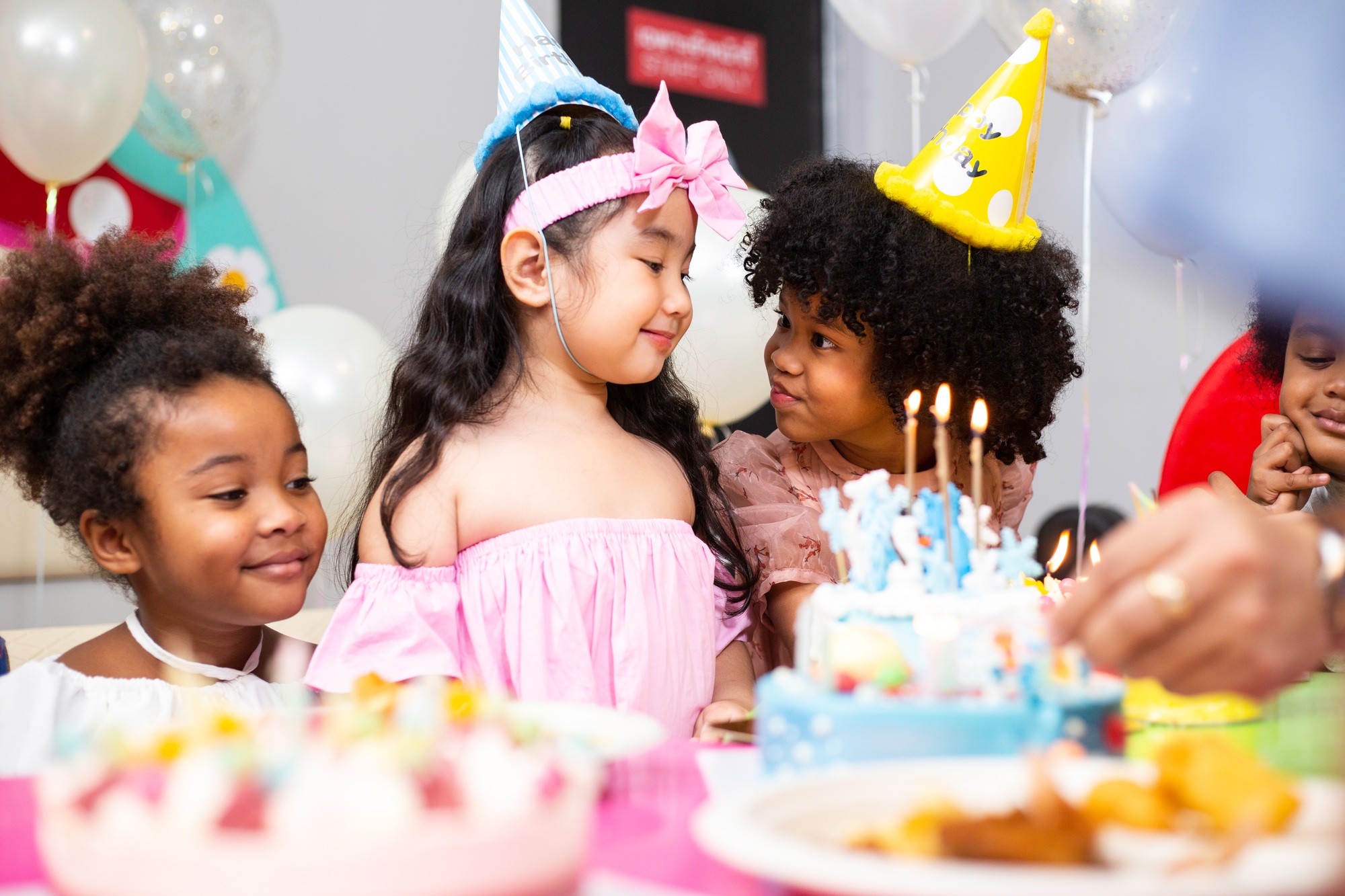 Group of little kids in party hat with birthday cake