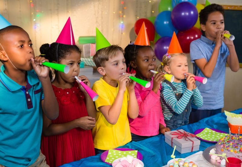 Playful children blowing party horns